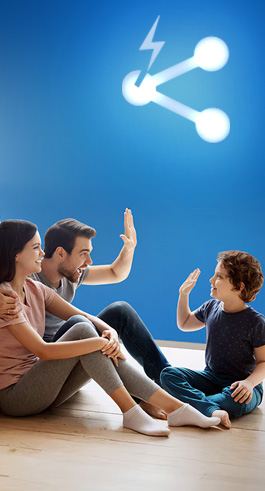 A young family sitting on the house floor with a blue background and the spodelitok logo illuminating the scene