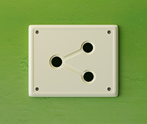 An elecric wall outlet with the shape of Spodelitok logo over a spodelitok green wall